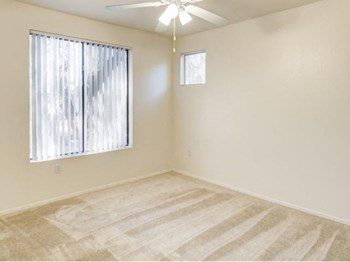 Ingleside Apartments bedroom with wall to wall carpet, a ceiling fan, and large window - Photo Gallery 17