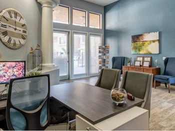 Ingleside Apartments Leasing Office desk with side chairs and blue accent wall - Photo Gallery 8