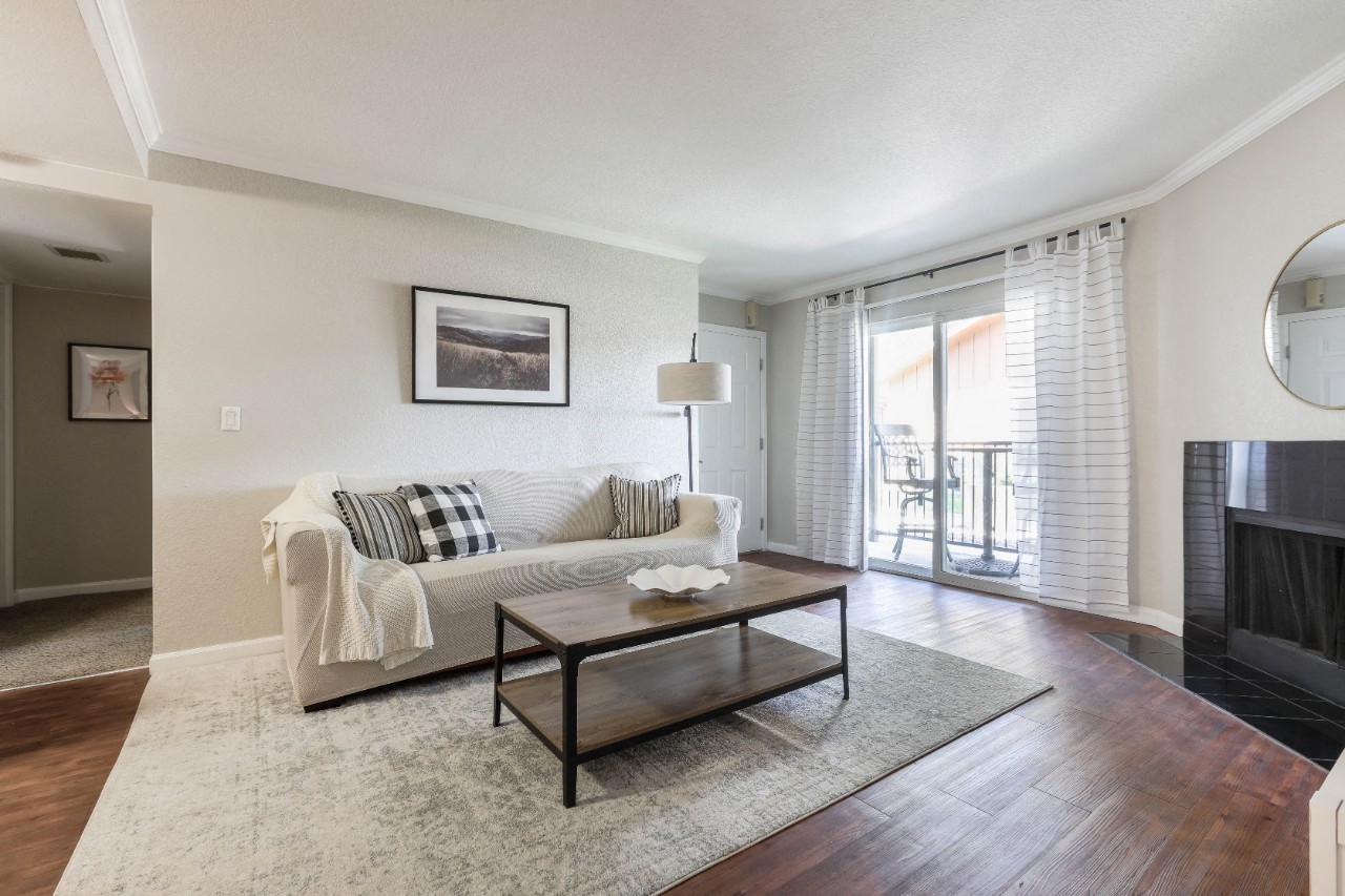 model living room with faux wood flooring, fireplace and sliding glass door to patio