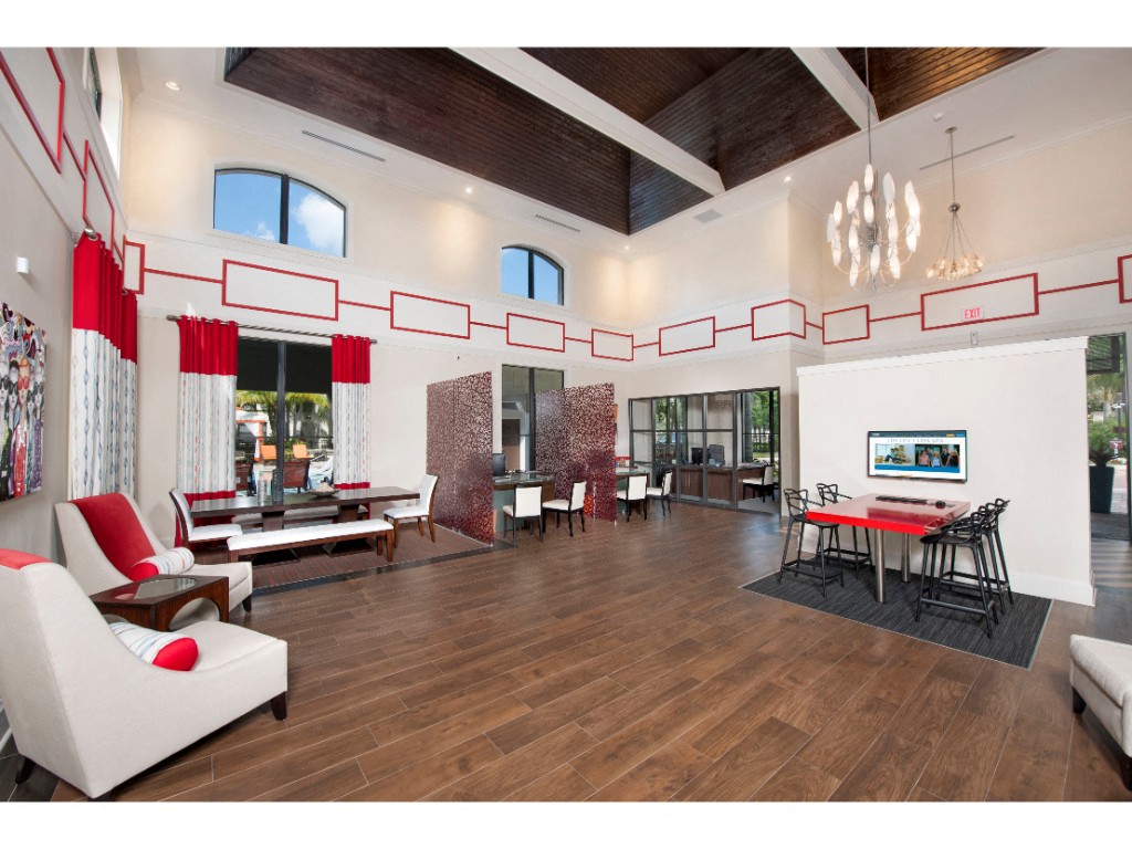 Leasing Office with high, wood-beamed ceilings with desks, chairs, and sitting area