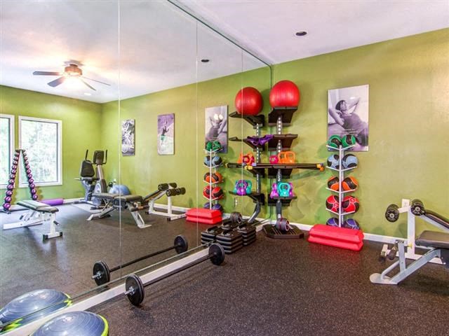 a workout room with weights and a mirror