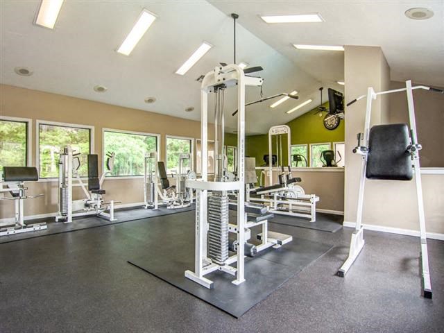 a gym with a lot of weights and a chair