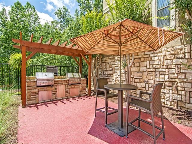 a patio with a table and chairs and an umbrella