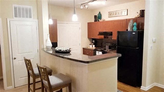 a kitchen with a counter top and a black refrigerator
