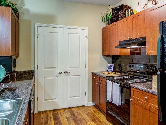 a kitchen with a stove and a white door