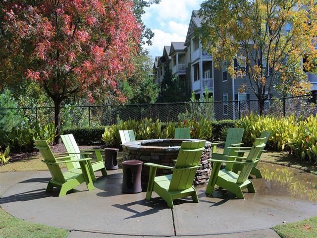 a group of green chairs sitting around a fire pit