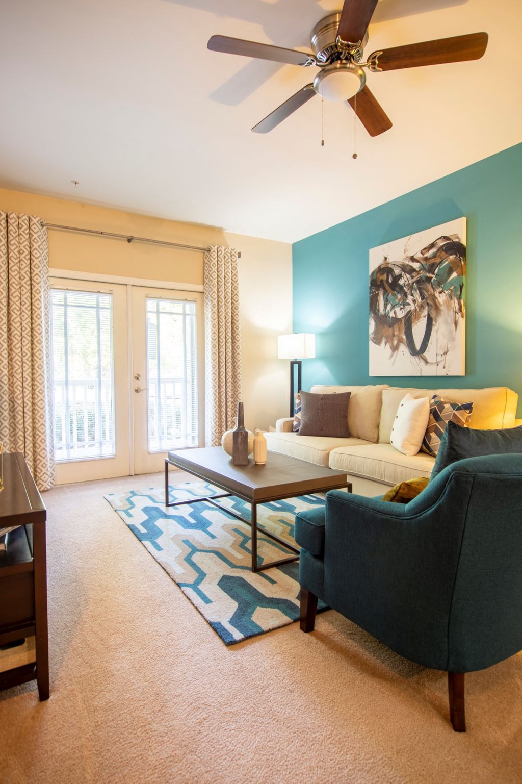 a living room with a couch and a chair and a ceiling fan