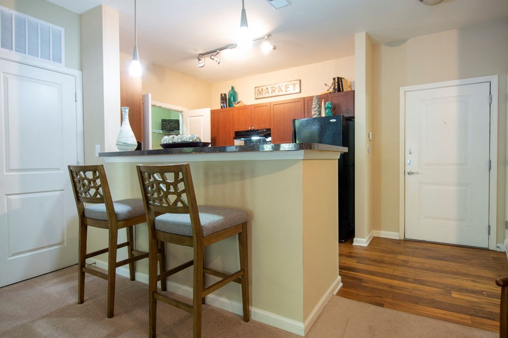 a kitchen with a counter and two chairs