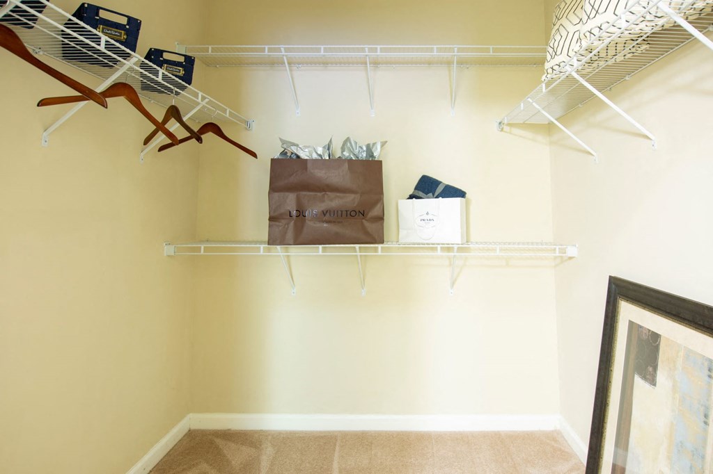 a walk in closet with shelves and a bag on a shelf