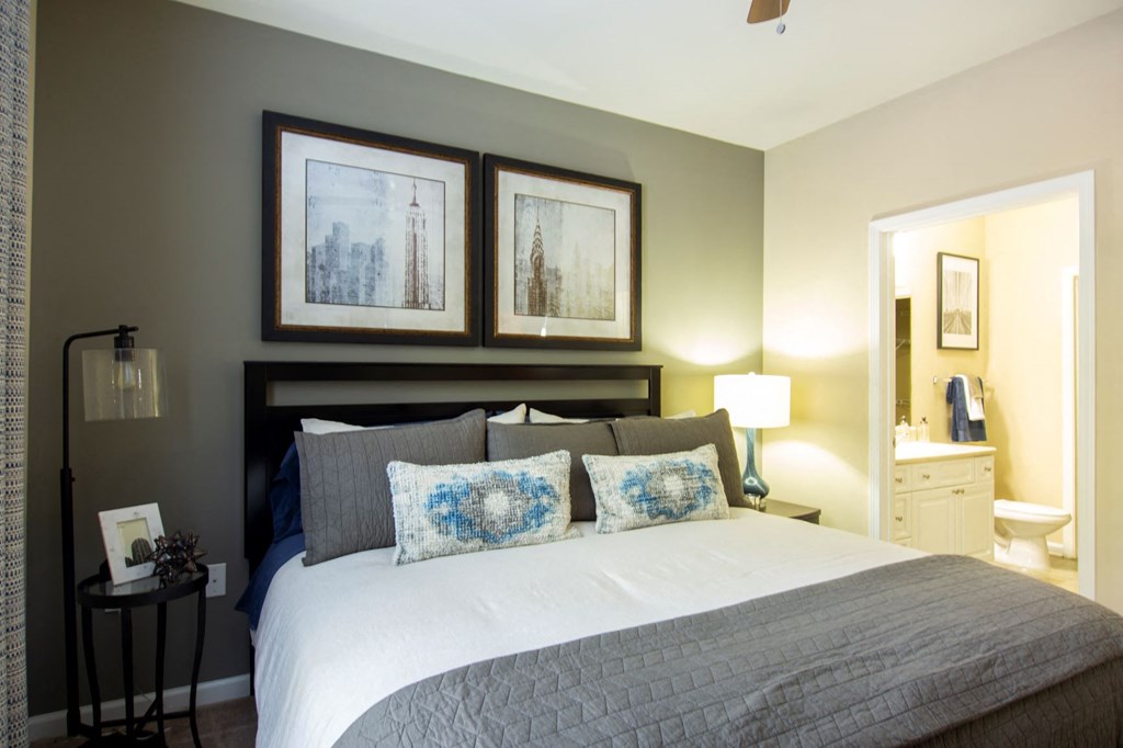 a bedroom with a bed and a bathroom with a sink