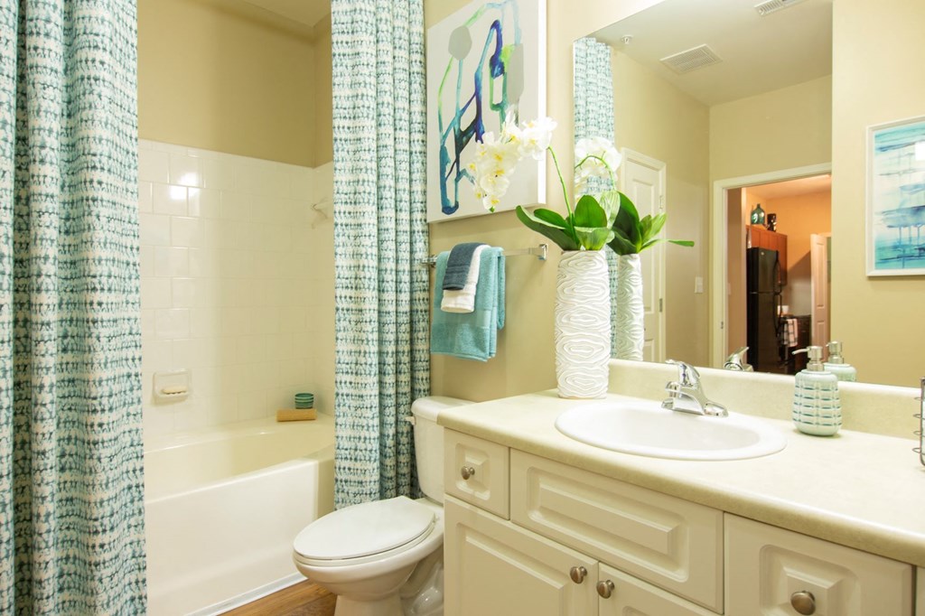 a bathroom with a shower curtain and a sink and a toilet
