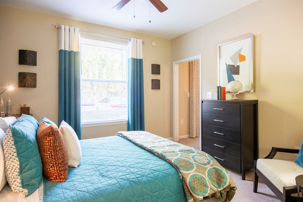 a bedroom with a bed and a dresser and a window