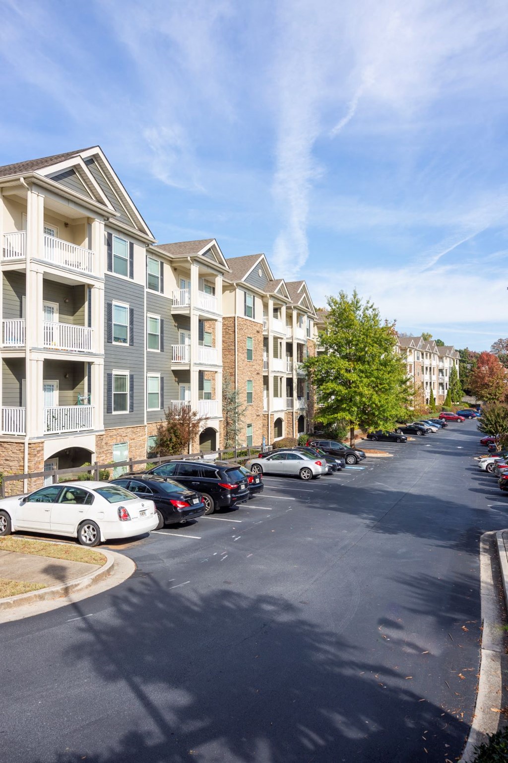 a street with cars parked in front of an apartment building