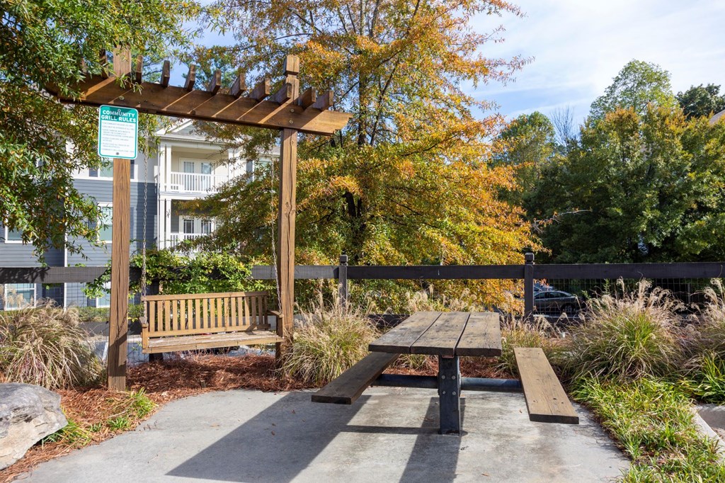 a picnic area with a bench and a pergola