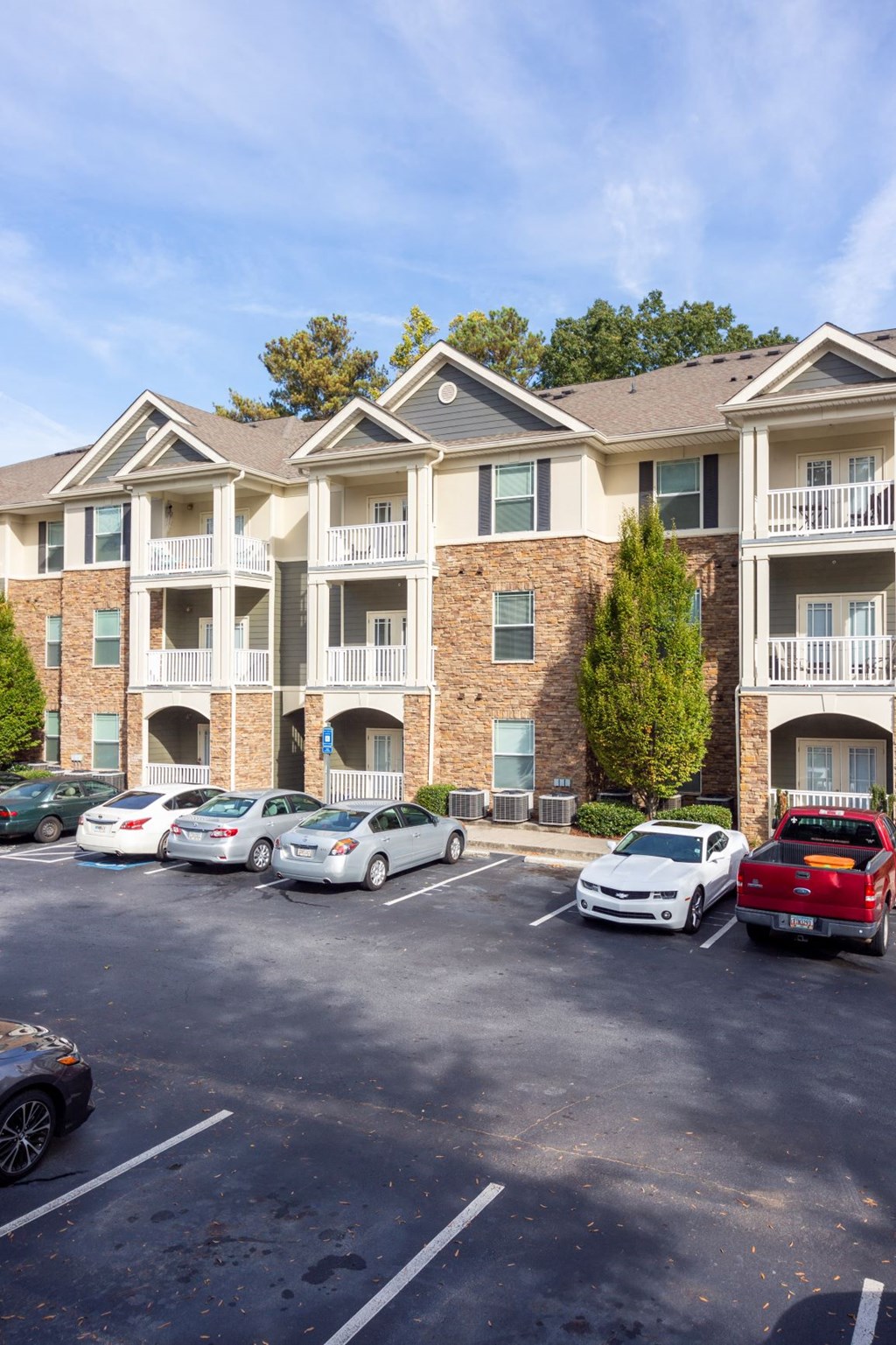 a parking lot with cars in front of an apartment building