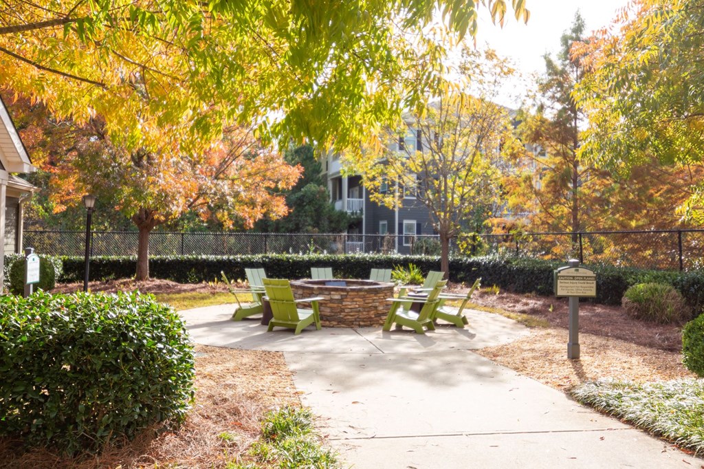 a patio with chairs and a fire pit