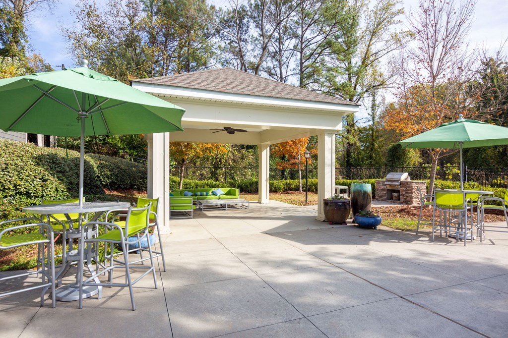 a patio with tables and chairs and umbrellas