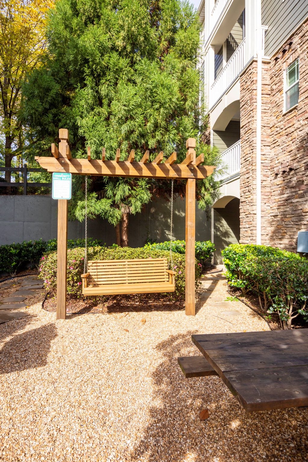a wooden swing in the courtyard of a building