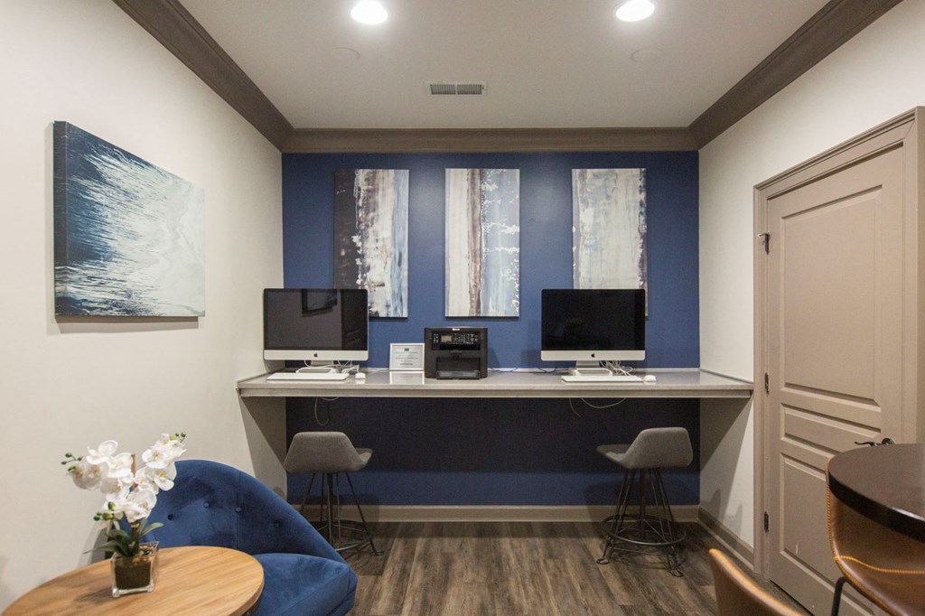 a home office with two computer monitors on a long desk