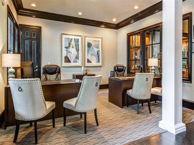 a room with a desk and chairs in it