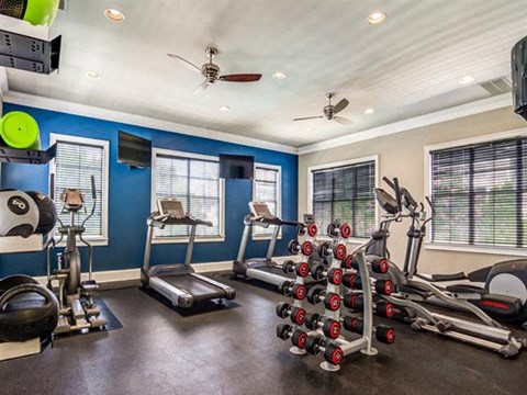 a home gym with exercise equipment and a ceiling fan