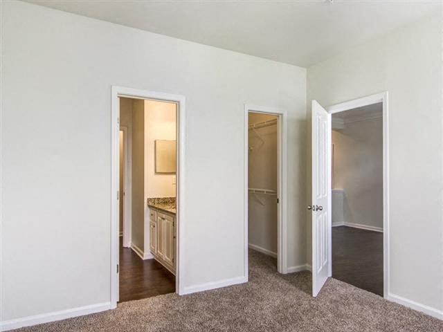 a room with three doors and a sink and a mirror