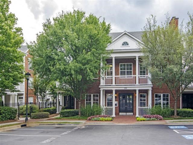 a large brick house with trees in front of it