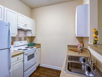 a kitchen with white appliances and a sink