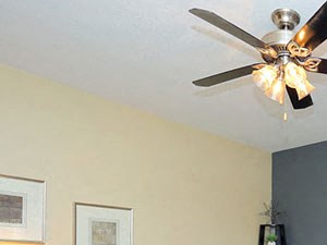 Spacious living room with ceiling fan and wood plank flooring