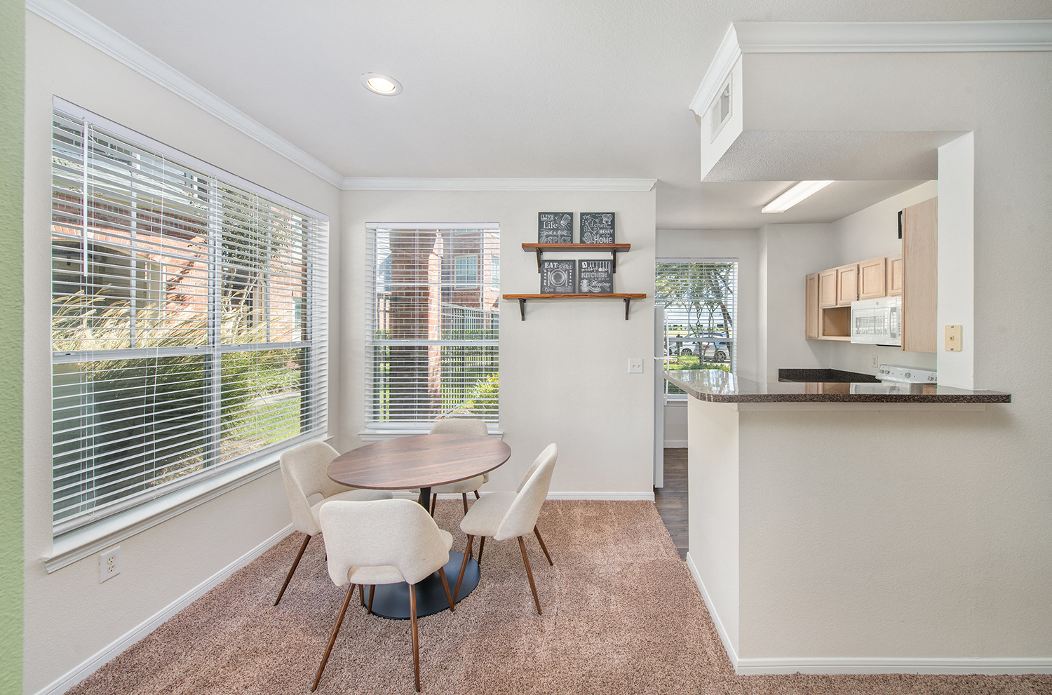 a dining room with a table and chairs and a kitchen