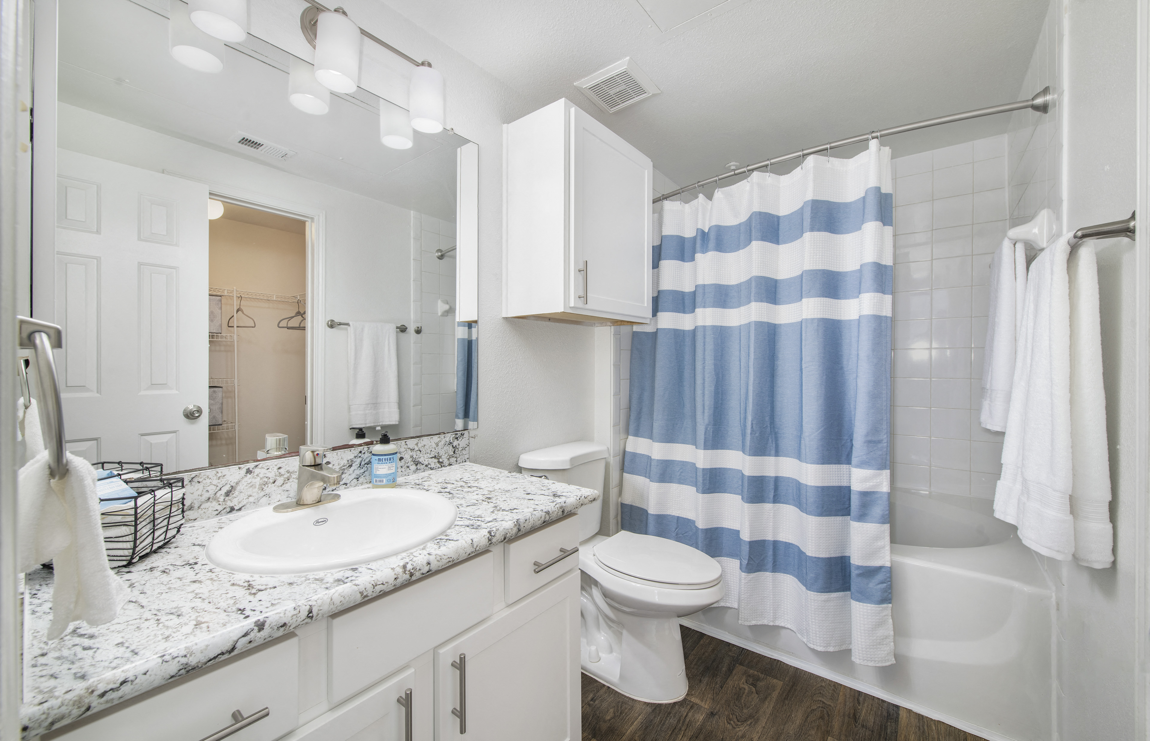 a white bathroom with a blue and white shower curtain