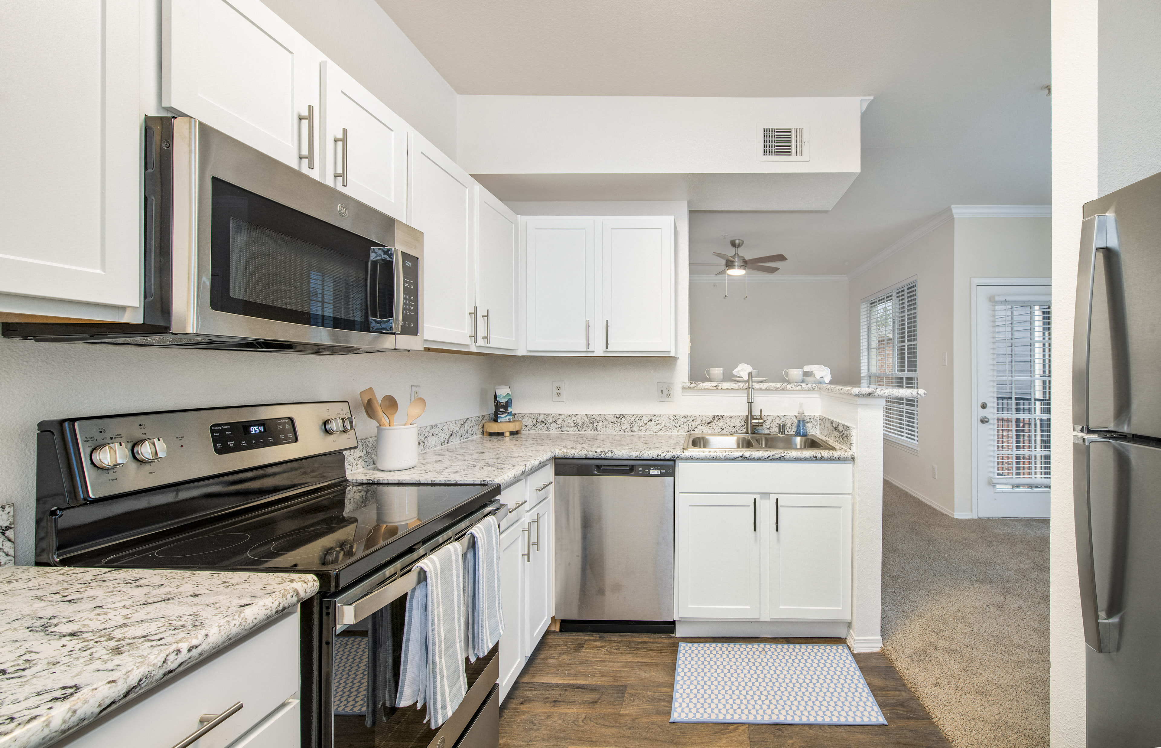 a renovated kitchen with white cabinets and stainless steel appliances