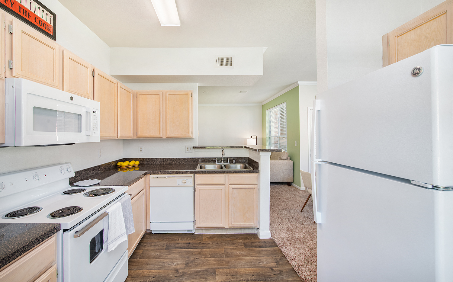 a renovated kitchen with white appliances and wooden cabinets