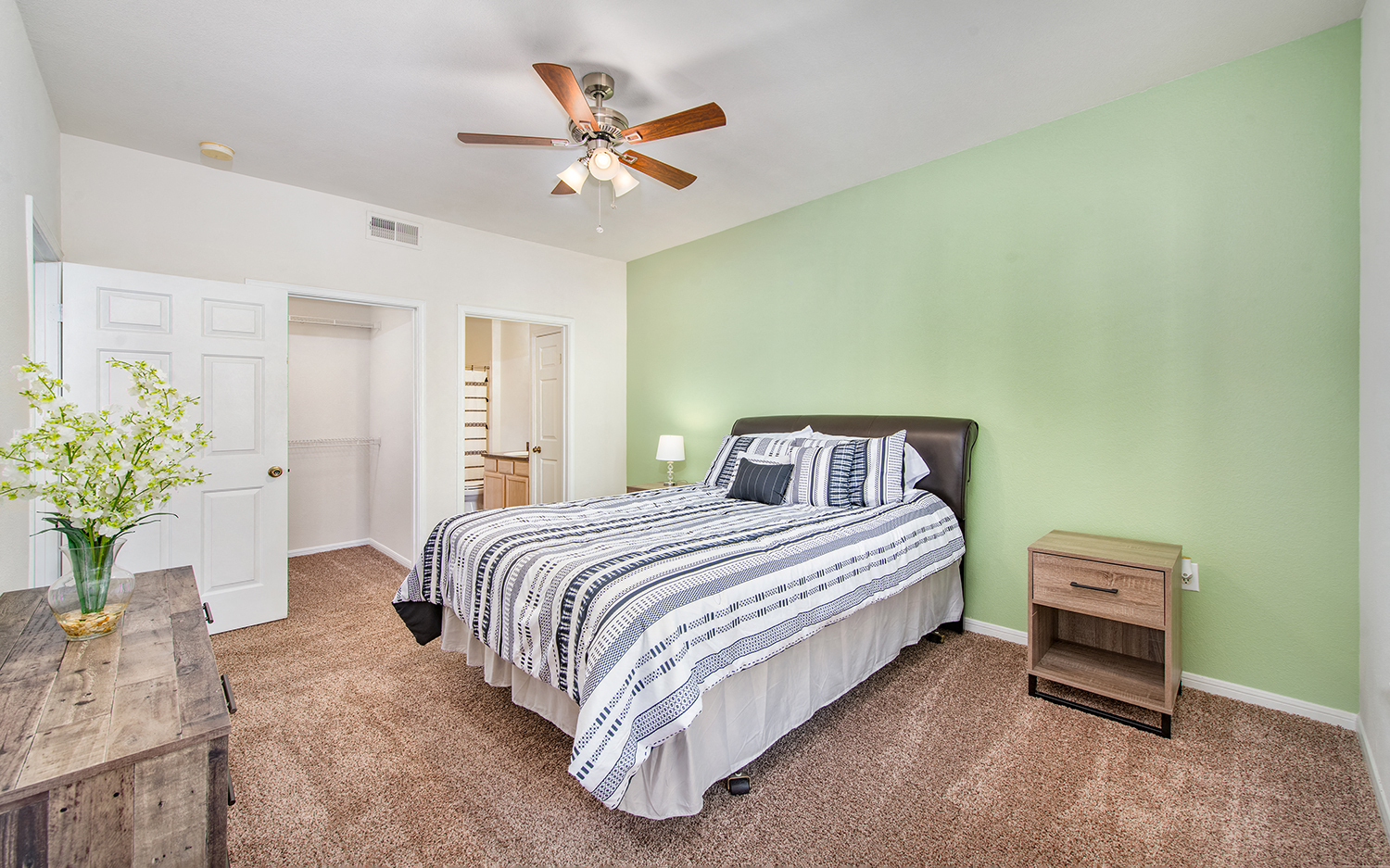 a bedroom with a bed and a ceiling fan