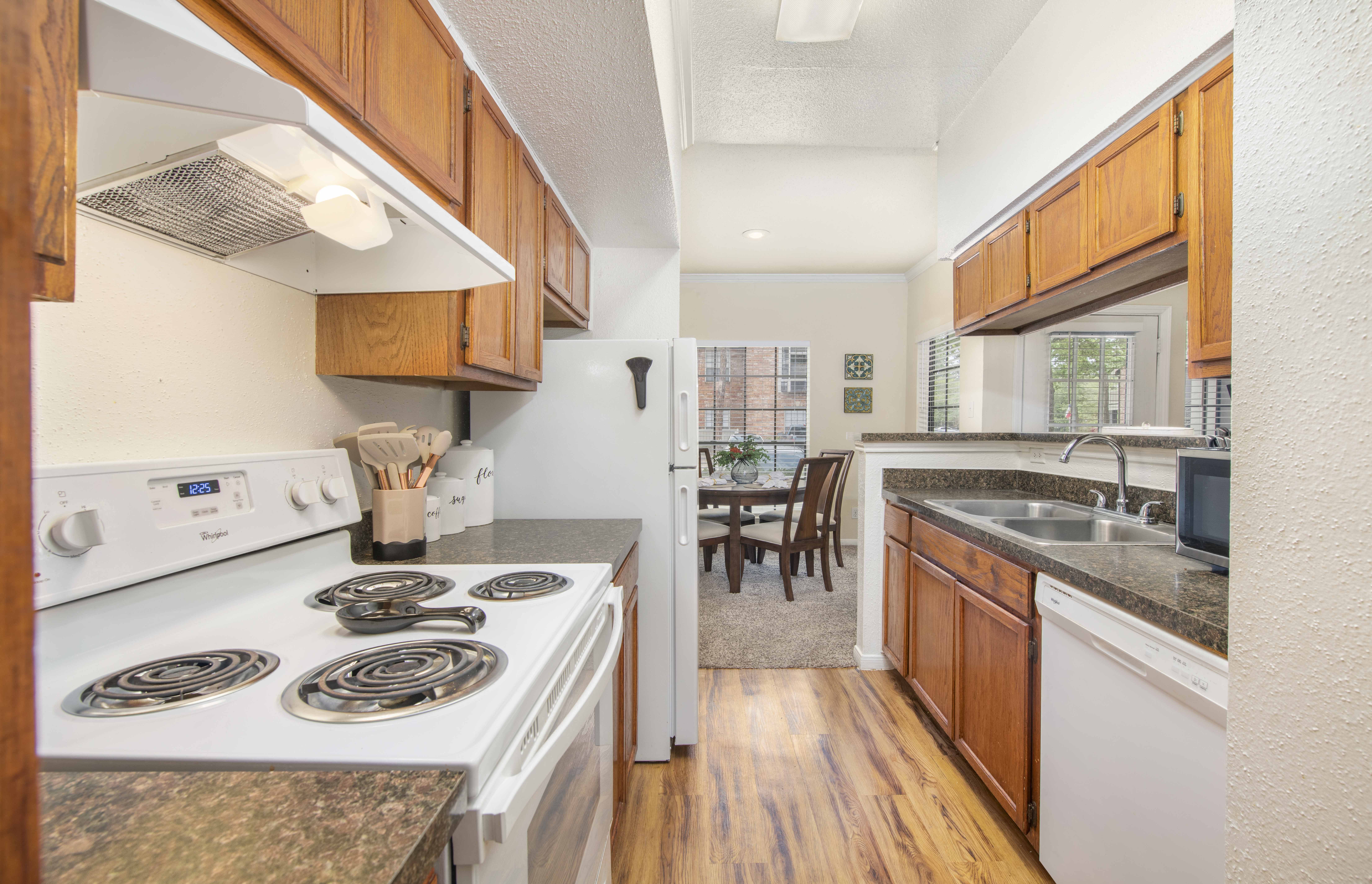 a kitchen with white appliances and wooden cabinets