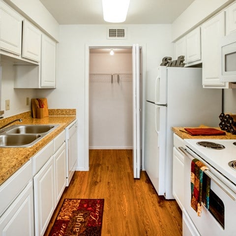 a kitchen with white cabinets and white appliances and a white refrigerator