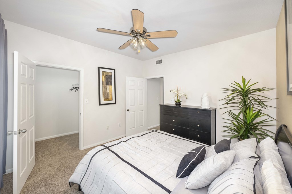 a bedroom with a large bed and a ceiling fan