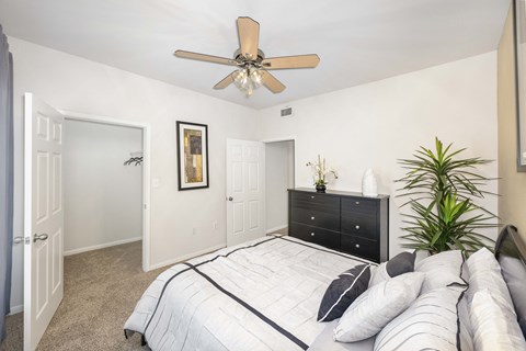 a bedroom with a large bed and a ceiling fan