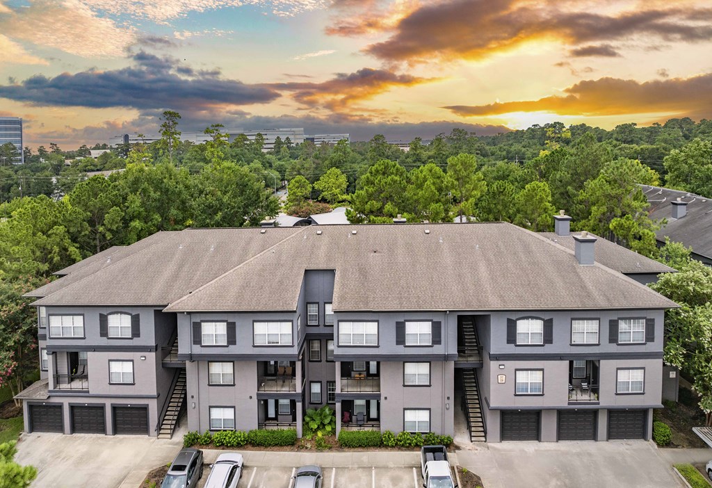 an aerial view of a building with a sunset behind it