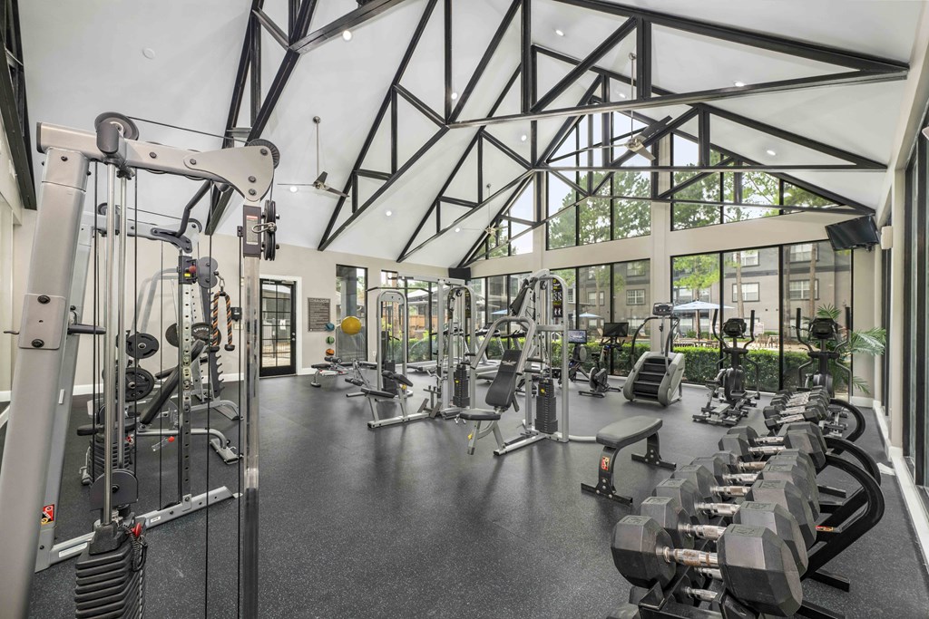 a gym with weights and other exercise equipment and a large glass window