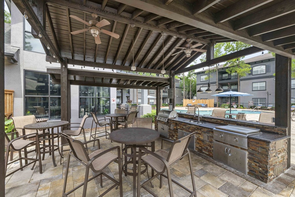 a patio with a bar and tables and chairs