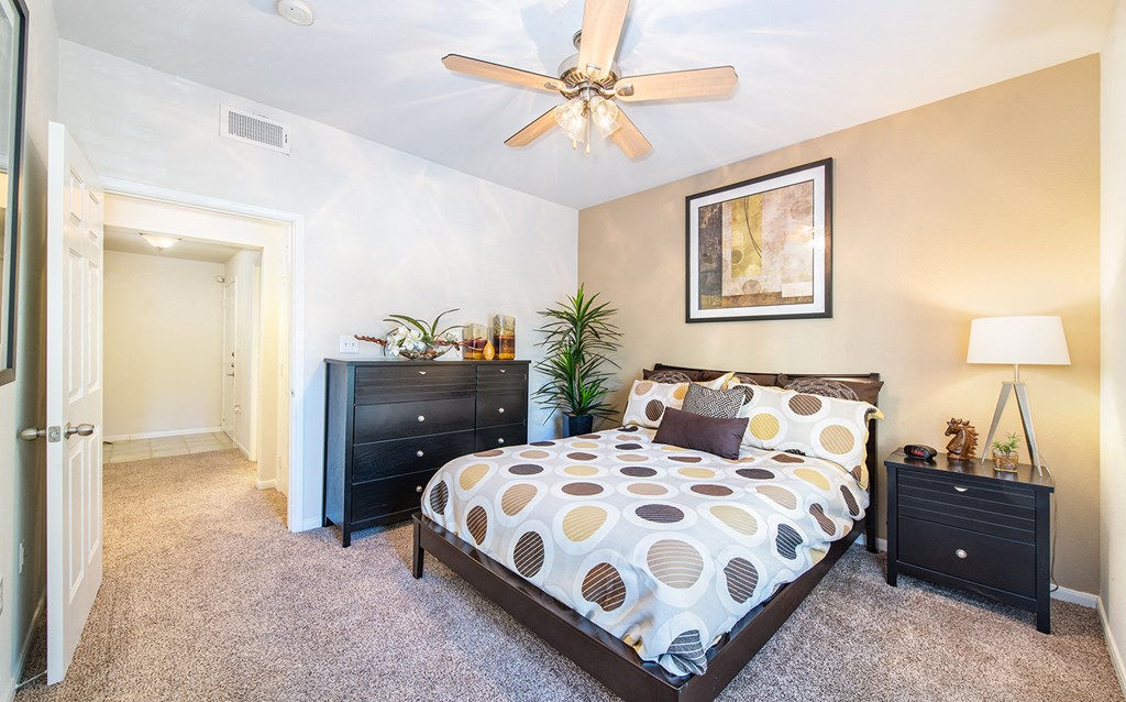 a bedroom with a bed and a ceiling fan