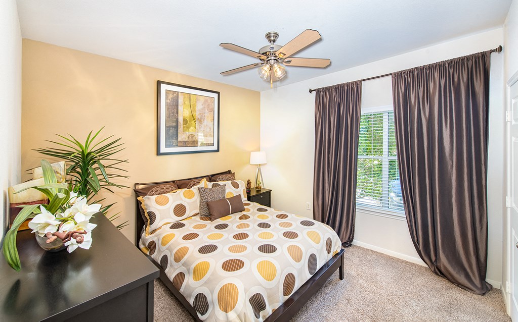 a bedroom with a bed and a ceiling fan