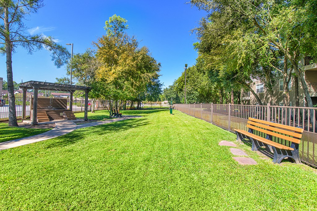 a park with benches and a fence
