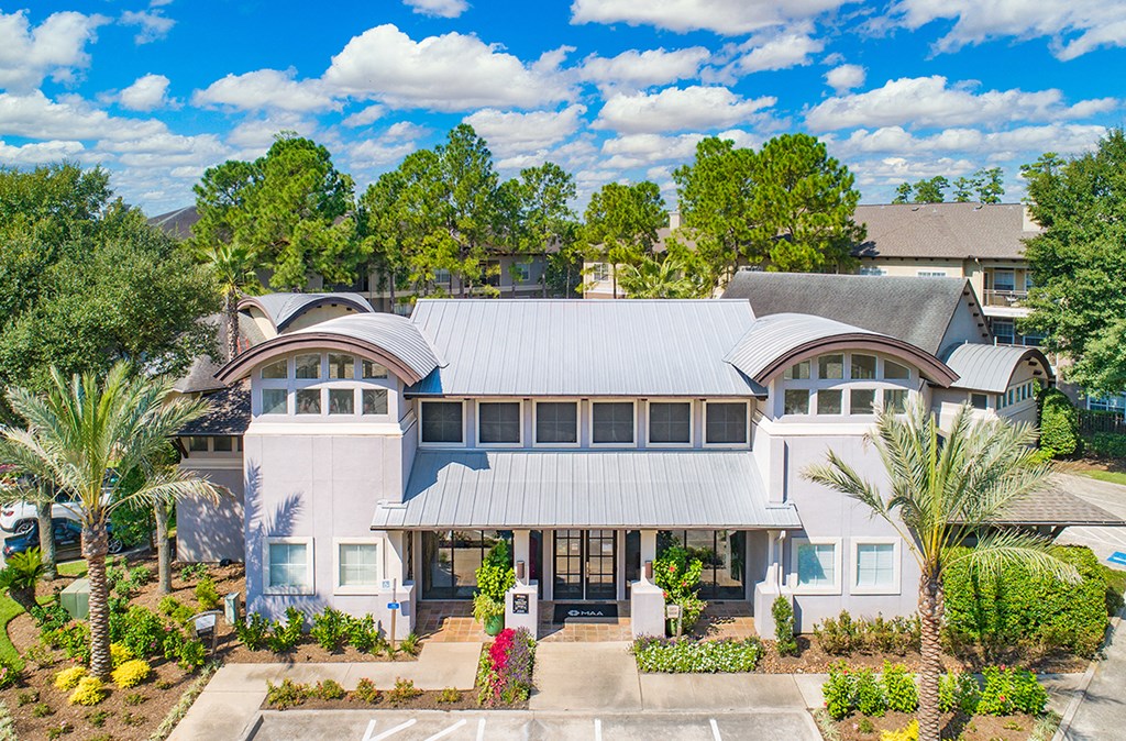 a white house with a gray roof and palm trees