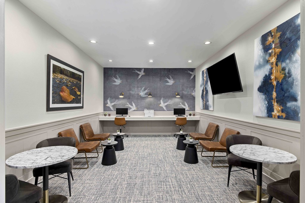 A room with a grey carpet and a large painting of a tree on the wall.