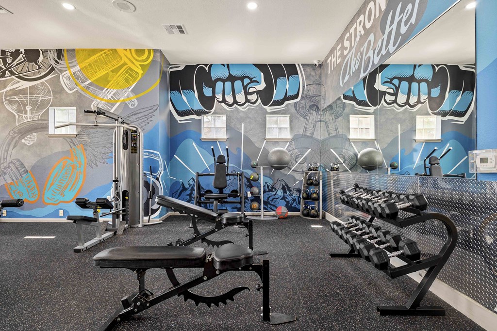 A gym with a blue wall and a variety of equipment.