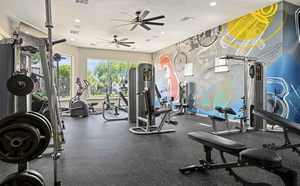A gym with a variety of equipment including weights and cardio machines.