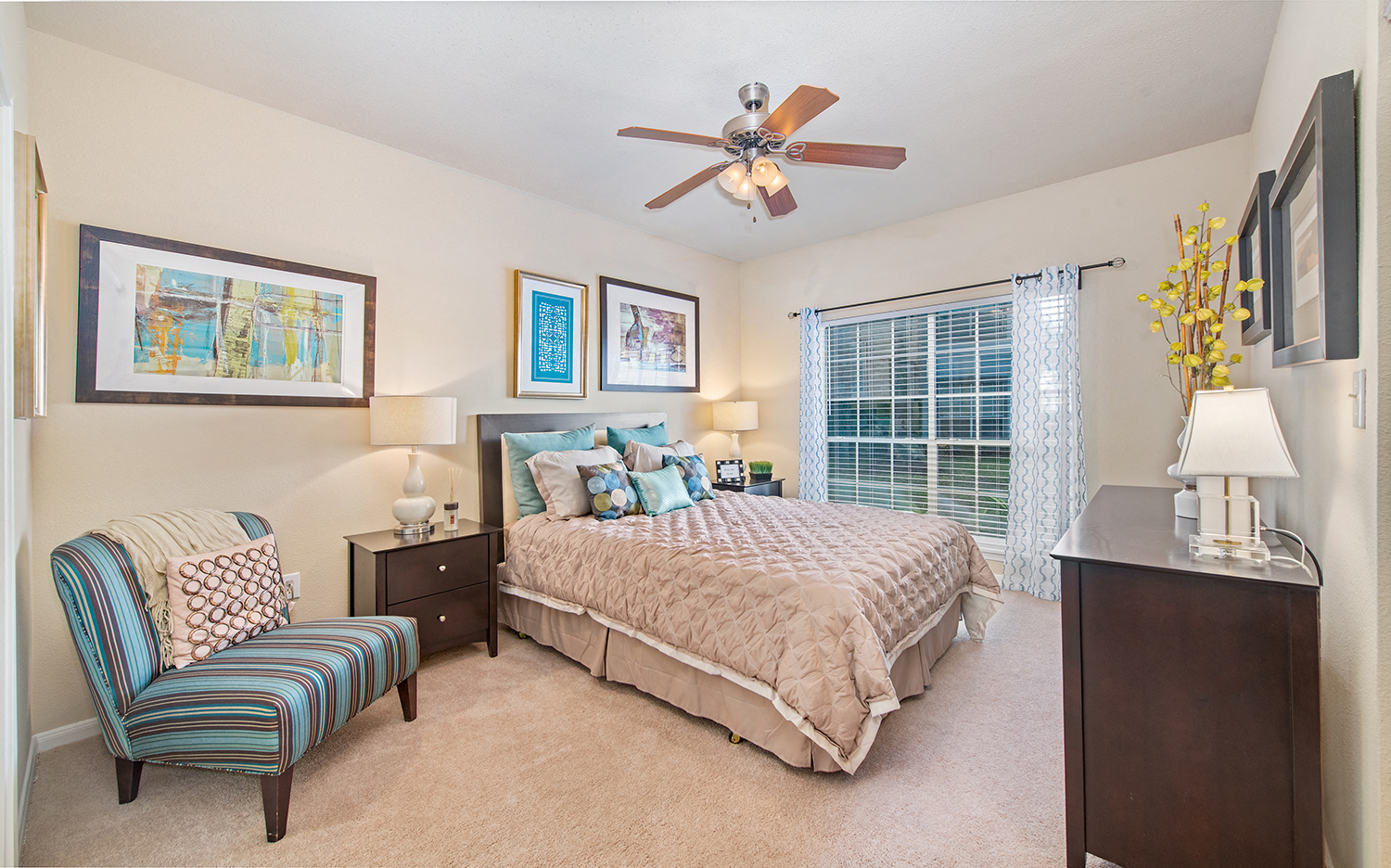 a bedroom with a large bed and a ceiling fan