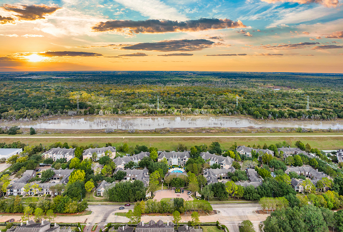 an aerial view of a neighborhood with houses and a sunset
